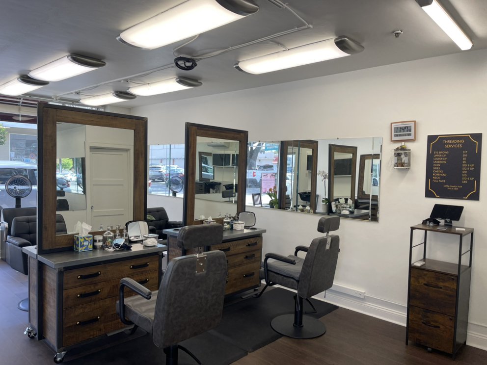 Threading stations with wood-framed mirrors and the service menu on the wall